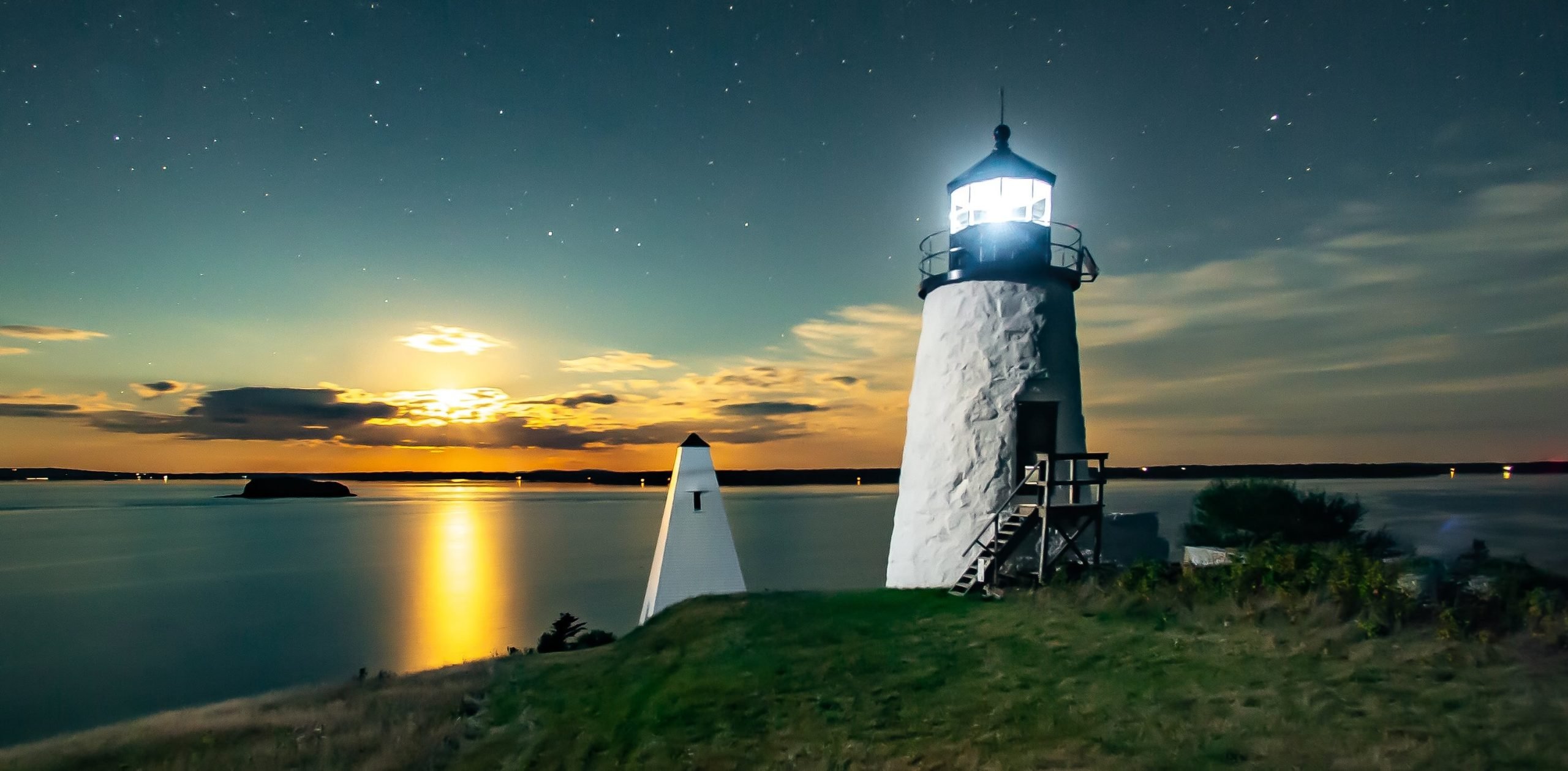 moonrise behind lit up eagle island lighthouse